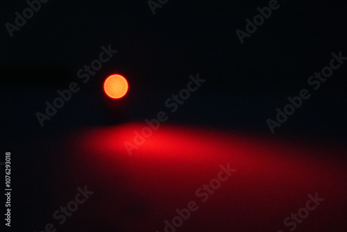 Obraz na płótnie A Person in the Snow Shining a Red Flashlight in the Dark w salonie