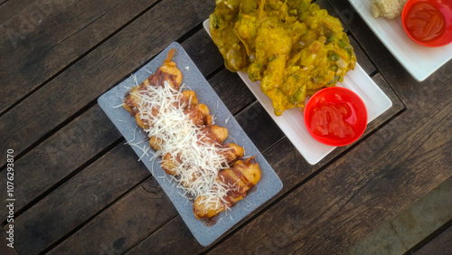 Fotografie A top-down view of an assortment of Indonesian street food served on a rustic wooden table