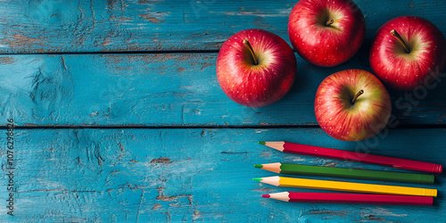 Arrangement of Apples and Colored Pencils on Rustic Blue Background
 photo