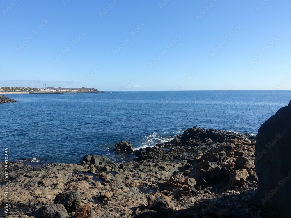 Rocky coastline and clear blue sea under a bright sky. Rocky coastline and clear blue sea under a bright sky.