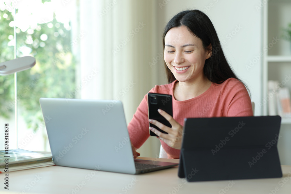 Happy asian woman using multiple devices at home Happy asian woman using multiple devices at home