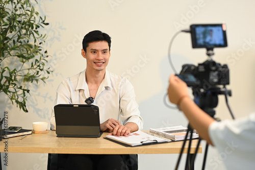 Successful young entrepreneur speaking on camera during office interview