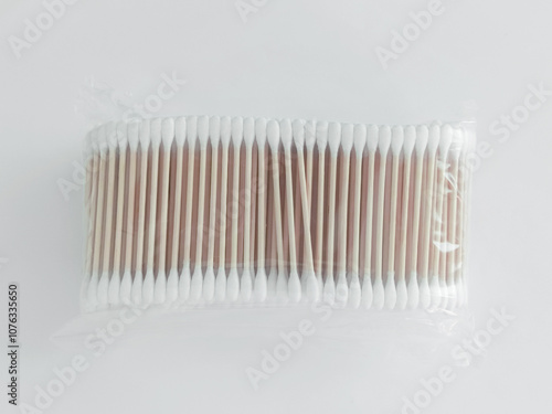 Bamboo brown cotton swabs in transparent packaging on white background. Top view. photo