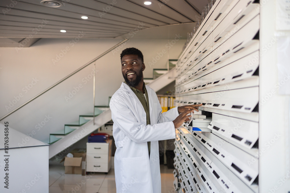 Smiling pharmacist standing near drawers at pharmacy Smiling pharmacist standing near drawers at pharmacy
