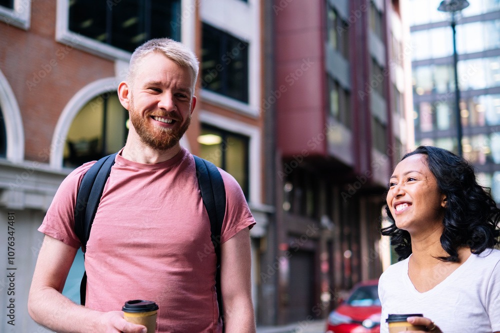 Happy couple standing with coffee cups in front of buildings Happy couple standing with coffee cups in front of buildings