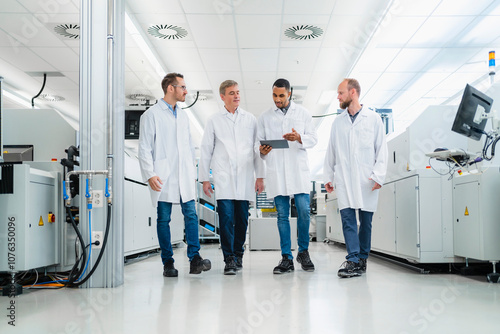 Technicians in lab coats having a meeting in electronics manufacture photo