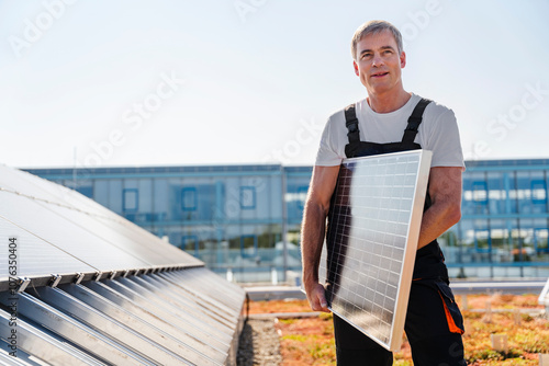 Craftsman holding solar panel on the roof of a company building