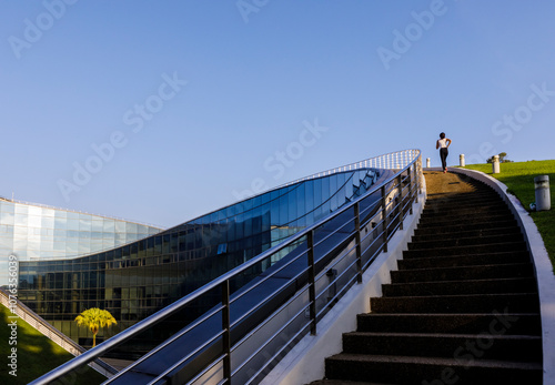 Young woman moving up on steps under clear sky