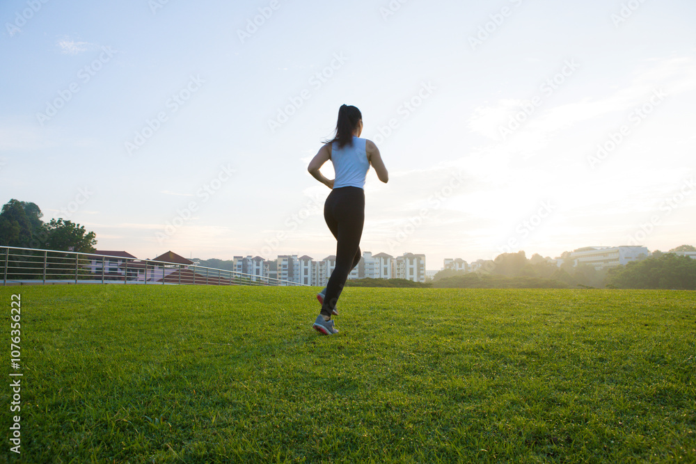 Young woman running on grassy on field at park Young woman running on grassy on field at park