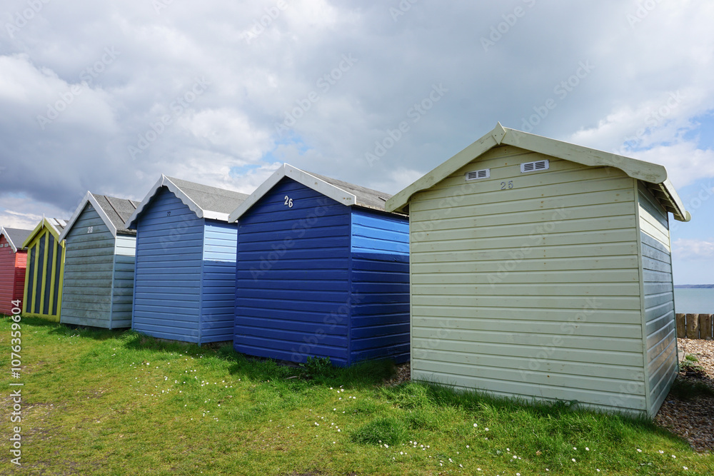 traditional wooden beach huts in a row on the coast. Colourful huts at the seaside traditional wooden beach huts in a row on the coast. Colourful huts at the seaside