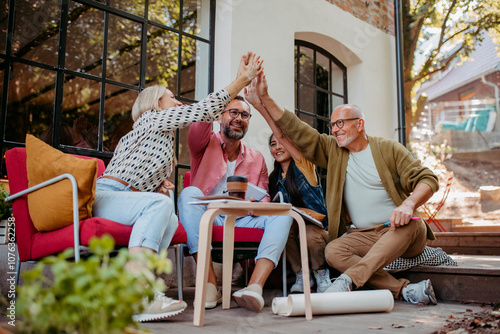 Group of people high fiving in front of community building photo