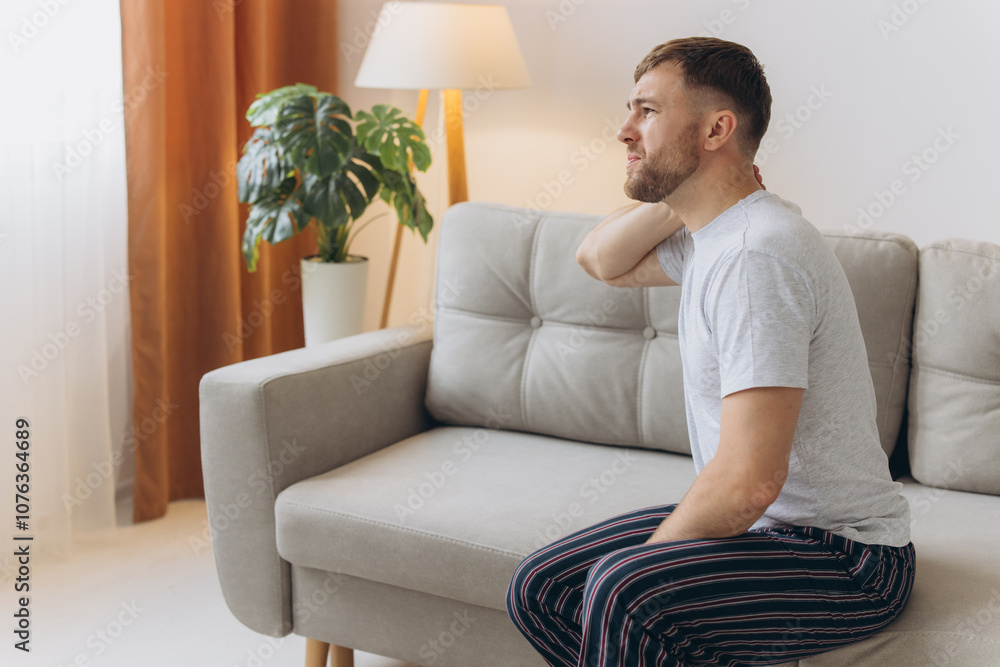 Neck Pain. Caucasian Man Massaging Aching Neck On Couch In Living Room At Home. Osteoarthritis, Health Problem Concept. Neck Pain. Caucasian Man Massaging Aching Neck On Couch In Living Room At Home. Osteoarthritis, Health Problem Concept.