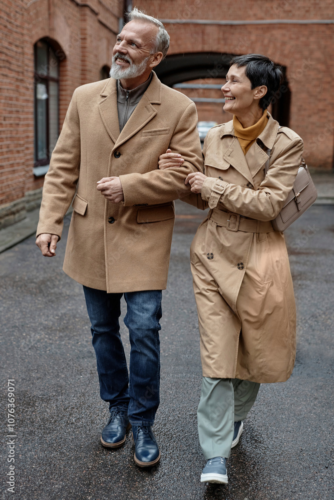 Happy couple enjoying autumn walk arm in arm Happy couple enjoying autumn walk arm in arm