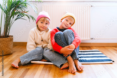 Brother and sister wearing knit hats at home photo