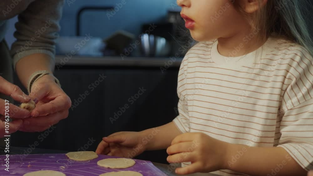 A little girl joyfully interacts in a modern kitchen, engaging in fun activities with a caregiver A little girl joyfully interacts in a modern kitchen, engaging in fun activities with a caregiver