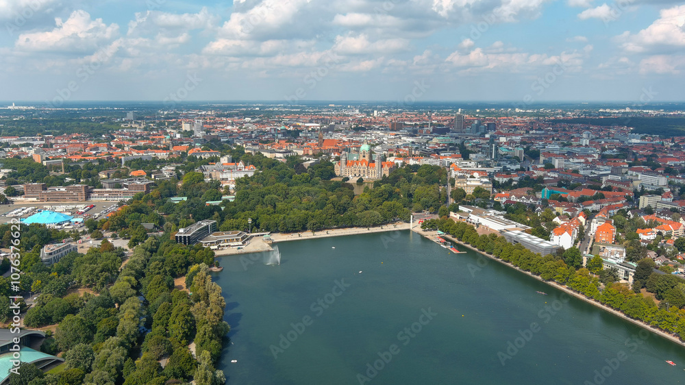 Fototapeta premium Expansive aerial view of Hannover's Maschsee lake and surrounding cityscape, a beautiful blend of nature and urban life.