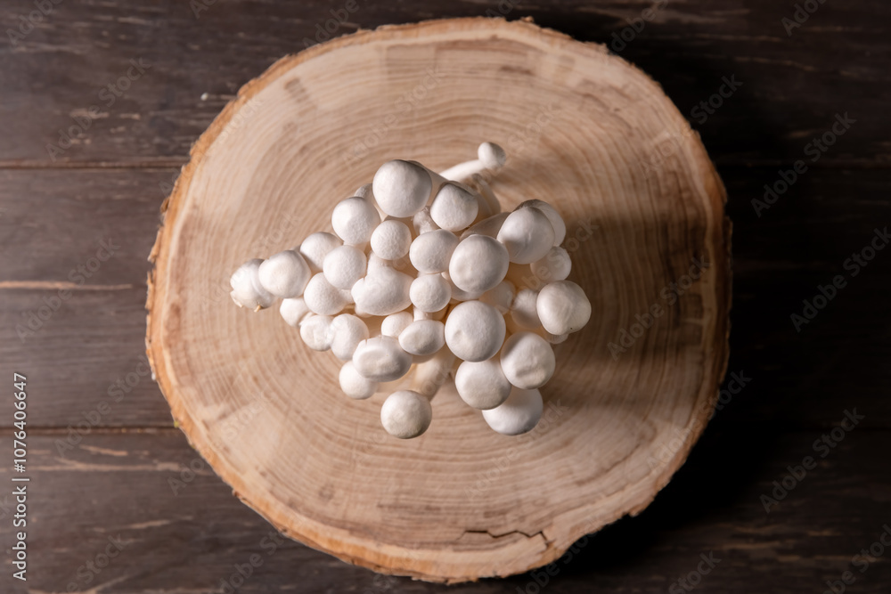 Closeup of a bunch of shimeji mushrooms on wooden background, with selective focus Closeup of a bunch of shimeji mushrooms on wooden background, with selective focus