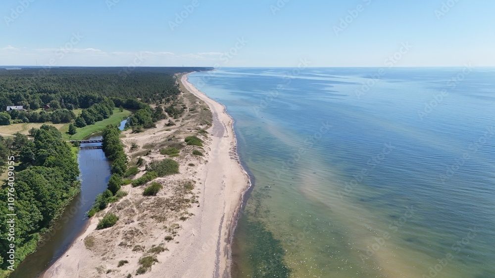Aerial view of a serene coastline with lush greenery and clear blue waters under a bright sky. Aerial view of a serene coastline with lush greenery and clear blue waters under a bright sky.