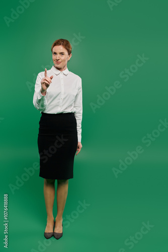 A poised woman in formal attire stands with a finger raised against a vibrant green backdrop