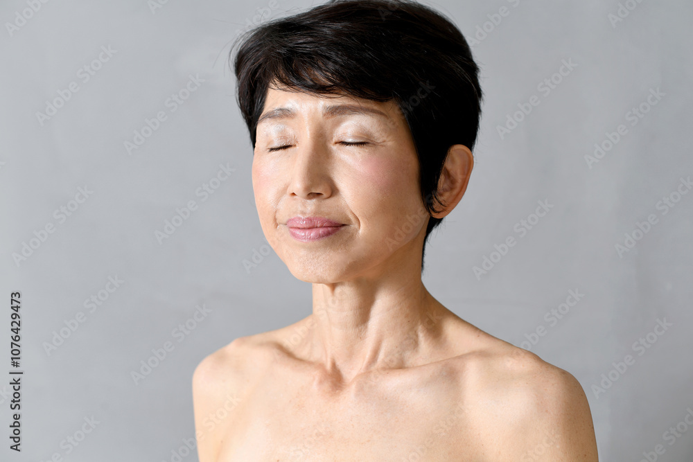 Obraz premium 目を瞑る中年のアジア人女性のイメージ