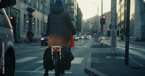 Wallpaper Mural Woman in winter clothing on cargo electric bicycle wait on traffic light. Cyclist riding with car traffic, crossing tram lines on bike. Cyclist city commuting in early morning on the way to office Torontodigital.ca