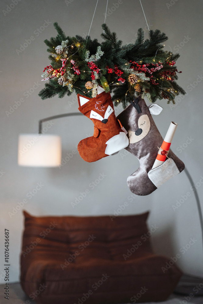Obraz premium Whimsical Christmas stockings in the shape of woodland animals like deer, foxes, hang as charming holiday decor. Their cozy, handmade designs add a playful and rustic touch to the festive atmosphere.