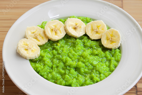 Plate of porridge with bananas, greens and whites. healthy food meal concept. a plate of porridge with bananas and greens on a white with white slices. a plate of porridge and with bananas, greens,.