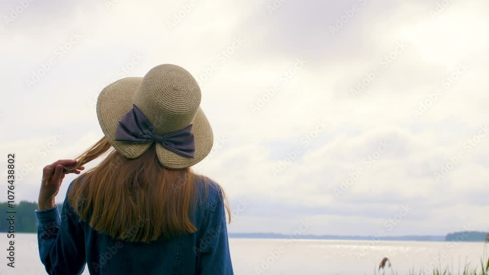 A woman in a blue dress walking on a pier by the lake and enjoying the view. Weekend by the lake. A woman in a blue dress walking on a pier by the lake and enjoying the view. Weekend by the lake.