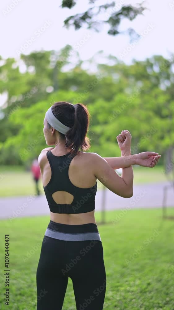 Vertical video of Active Woman in Park Stretching in Athletic Wear and Headband, Embracing Fitness and Exercise Amidst Lush Greenery Outdoors Vertical video of Active Woman in Park Stretching in Athletic Wear and Headband, Embracing Fitness and Exercise Amidst Lush Greenery Outdoors