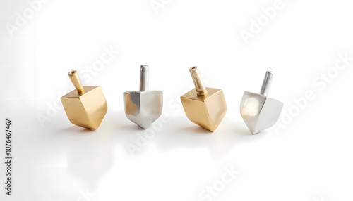 Gold and silver dreidels arranged on white background