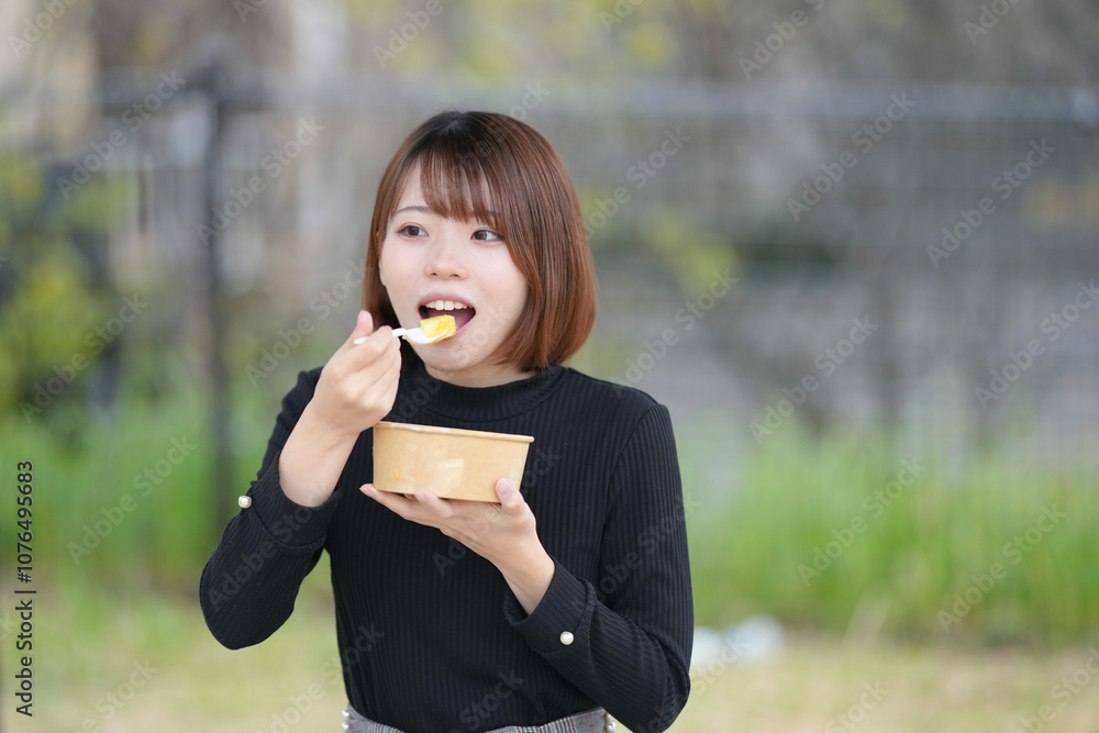A young woman in her 20s with short hair wearing a black knitted long-sleeved shirt is sitting in a pavilion in an empty park and eating fruits such as dragon fruit, pineapple, and strawberries. A young woman in her 20s with short hair wearing a black knitted long-sleeved shirt is sitting in a pavilion in an empty park and eating fruits such as dragon fruit, pineapple, and strawberries.
