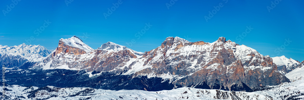 Wide winter panorama of mountain range in Italian Dolomites viewed from the slopes in Arabba ski resort top the West. Blue sky and copy space