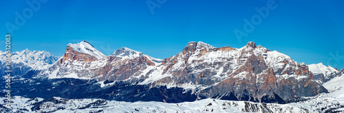 Obraz na płótnie Wide winter panorama of mountain range in Italian Dolomites viewed from the slopes in Arabba ski resort top the West. Blue sky and copy space w salonie