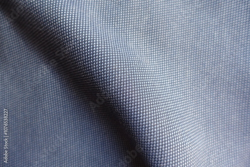 Diagonal fold on striped cotton fabric in shades of blue