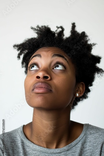 Woman with dark curly hair looking up.