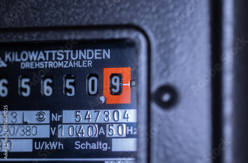 Close-up power consumption, analog electricity meter in the basement. Measuring used electricity in kWh ( kilowatt hour ) photo