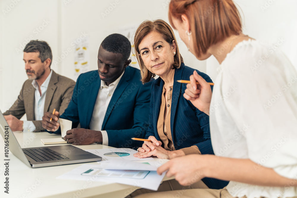 Diverse business team analyzing financial data mature female executive leading multigenerational meeting professional workplace collaboration discussion Diverse business team analyzing financial data mature female executive leading multigenerational meeting professional workplace collaboration discussion