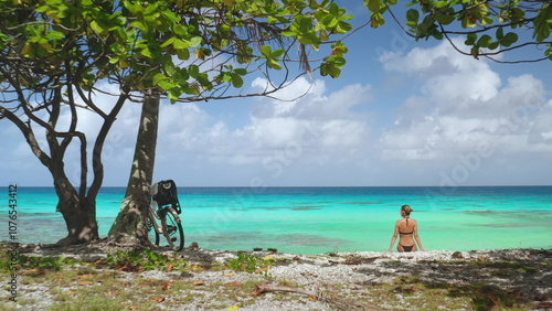 Tourist is enjoying a well-deserved rest on a pristine beach after a bike ride, surrounded by the breathtaking beauty of rangiroa island in french polynesia