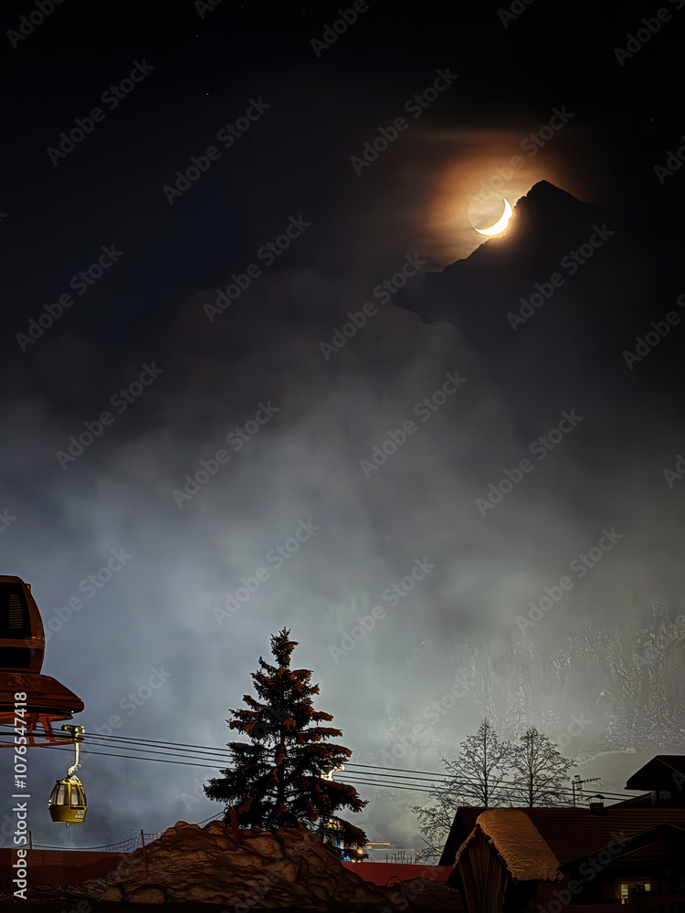 The moon above Alta Badia, Italy at night in winter