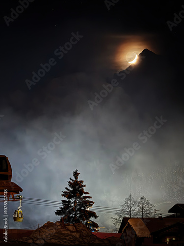 The moon above Alta Badia, Italy at night in winter