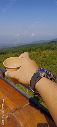 Enjoy a glass of milk coffee with a beautiful and fresh forest view in the background