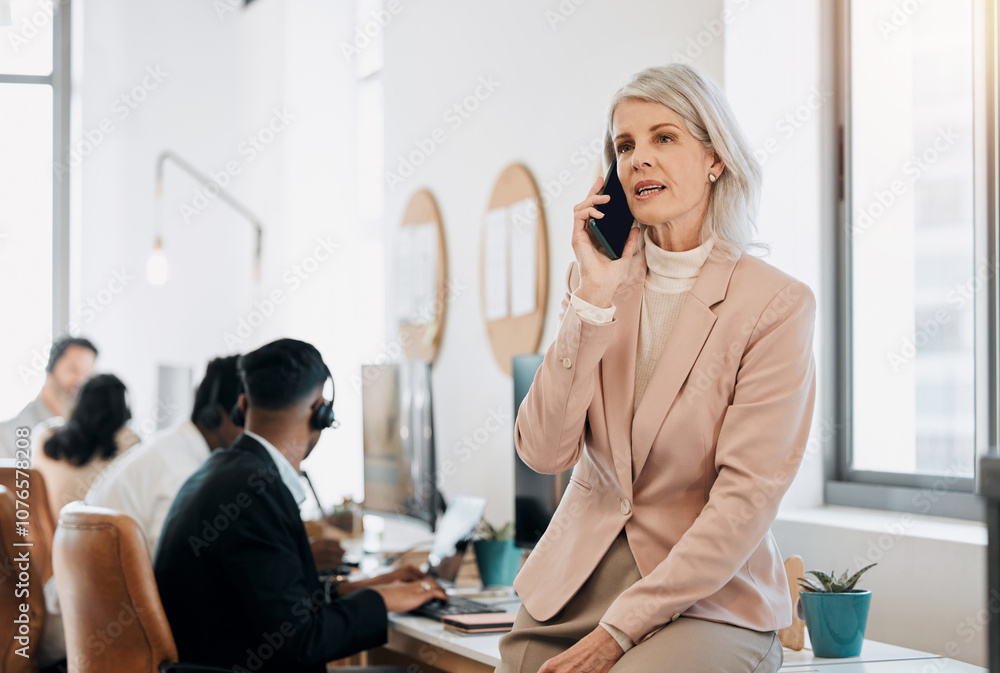 Mature woman, phone call and talk in contact center in office with team, listen and leader with customer service. Person, crm and smartphone for tech support, job or help desk at telemarketing agency Mature woman, phone call and talk in contact center in office with team, listen and leader with customer service. Person, crm and smartphone for tech support, job or help desk at telemarketing agency