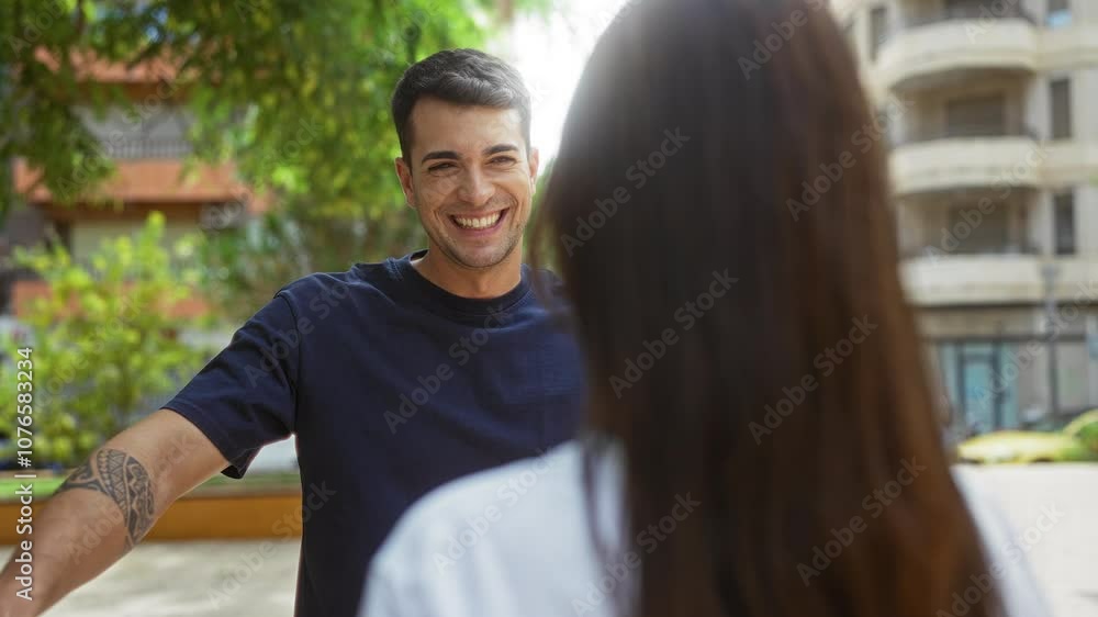 Man smiling and hugging a woman in an outdoor urban park setting, conveying happiness and connection amidst city surroundings Man smiling and hugging a woman in an outdoor urban park setting, conveying happiness and connection amidst city surroundings