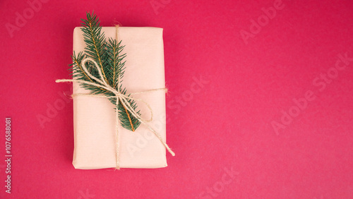 Greeting background. Gift wrapping in brown paper on a pink background with copy space. Top view