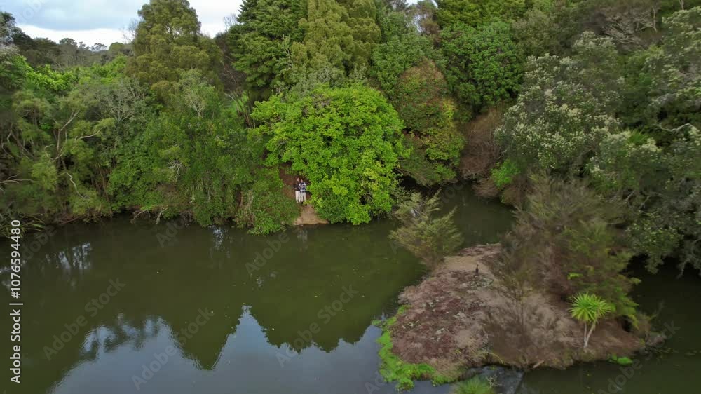 Couple fly drone lake surrounded by forest in Auckland New Zealand nature landscape Couple fly drone lake surrounded by forest in Auckland New Zealand nature landscape