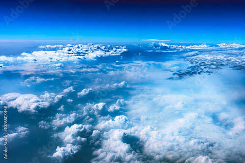 Aerial view from airplane window above green ground. View from the airplane window with beautiful clouds at sunrise. Earth and sky as seen through window of an airplane.