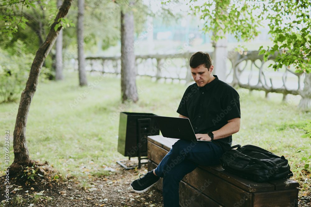 Portrait of young freelance programmer man working with laptop in forest park, software developer, IT technologies Portrait of young freelance programmer man working with laptop in forest park, software developer, IT technologies