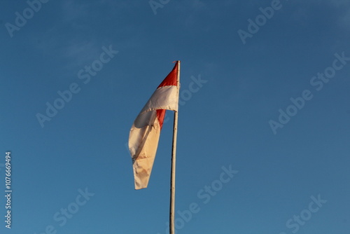 National Indonesian flag waving in the wind on blue sky background photo