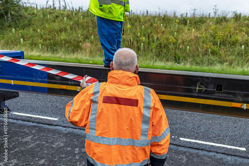 Blue HGV lorry truck extendable flatbed trailer being extended at roadside for wind turbine route test photo