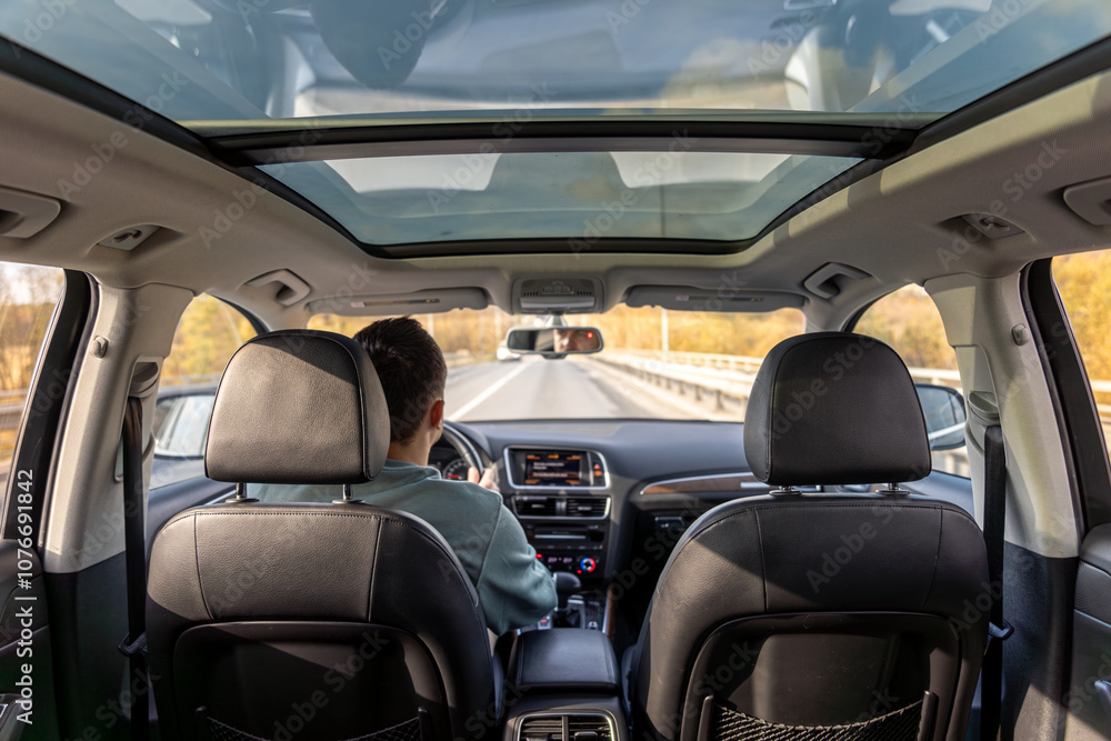 Driving the modern car on asphalt road. A young man drives a car. Driving the modern car on asphalt road. A young man drives a car.